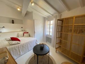 a bedroom with a bed and a table in it at La Conquette 2 in Saint-Tropez