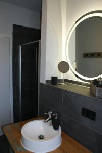 een badkamer met een witte wastafel en een spiegel bij Dock2Apartment Rügen Whg 3 großer Balkon, ruhige Lage in Lohme