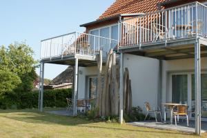 een huis met een patio met stoelen en parasols bij Dock2Apartment Rügen Whg 3 großer Balkon, ruhige Lage in Lohme