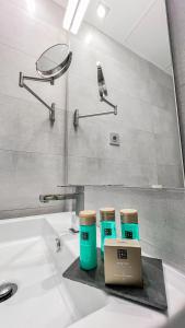 a bathroom sink with three cups and a laptop on it at La Serena Mar, Benalmadena Pueblo, Luxury Apartment with Jacuzzi in Benalmádena