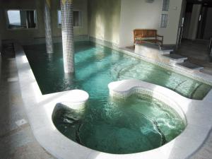 una piscina de agua verde en un edificio en Lagrange Vacances Les Chalets de l'Adet en Saint-Lary-Soulan