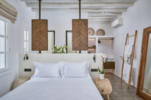 a bedroom with a white bed and two lamps at Ubud Mykonos in Agios Ioannis Mykonos