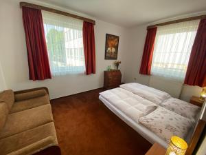 1 dormitorio con cama, sofá y ventanas en Penzión TATRA INN, en Čadca
