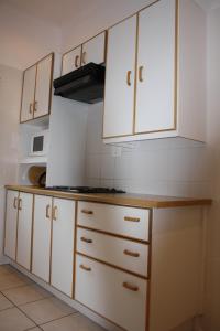 cocina con armarios blancos y fogones en Cozi Corner, en Queenstown