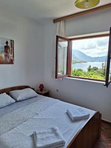 sypialnia z łóżkiem i dużym oknem w obiekcie B & M Apartments w Kotorze