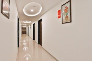 a hallway with white walls and a white ceiling at Collection O 12462 Hotel Shiv Inn in Adalaj