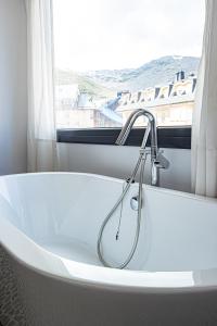 uma banheira na casa de banho com uma janela em Holidays, Edelweiss, 1 dormitorio, 4 personas em Sierra Nevada