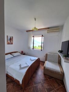 1 dormitorio con cama, ventana y silla en B & M Apartments, en Kotor