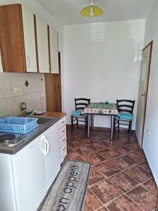 cocina con fregadero y mesa con sillas en B & M Apartments, en Kotor
