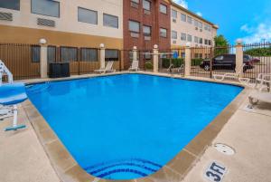 a large swimming pool with chairs and a building at Quality Inn & Suites in Waco