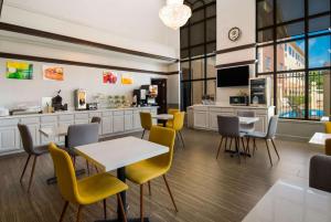 a restaurant with tables and chairs and a kitchen at Quality Inn & Suites in Waco