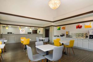 ein Restaurant mit gelben Stühlen, Tischen und einer Theke in der Unterkunft Quality Inn & Suites in Waco
