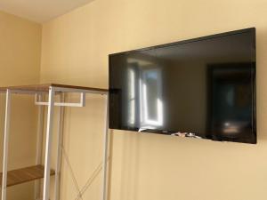 una TV a schermo piatto appesa a un muro di Casa Quinterni ad Alba