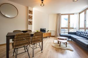 Una sala de estar con una mesa y sillas y un sofá. en Acebo 2 dormitorios, en Sierra Nevada