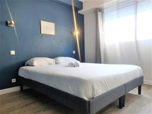 Le Nogué - Idéal Couples - Charmant Cocon في بو: سرير كبير في غرفة نوم بجدار ازرق