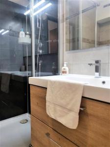 y baño con lavabo blanco y espejo. en Le Nogué - Idéal Couples - Charmant Cocon, en Pau