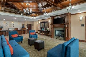 a living room with blue furniture and a fireplace at Comfort Inn & Suites Fort Worth - Fossil Creek in Fort Worth