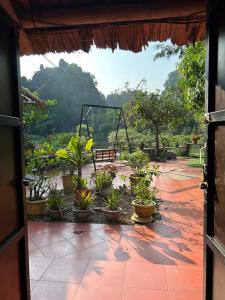 a view of a patio with potted plants and a swing at Tam Coc Bungalow in Ninh Binh