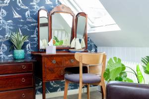 a bedroom with a desk with a mirror and a chair at The Old Schoolhouse in Whitstable