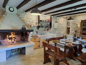 a kitchen with a fireplace and a table and chairs at Authentic Stone House Lola in Grabovac