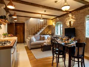 a kitchen and living room with a table and a couch at Authentic Stone House Lola in Grabovac
