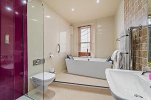 a bathroom with a tub and a toilet and a sink at The Rutland Hotel in Sheffield