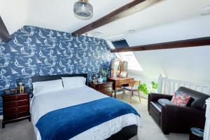 1 dormitorio con cama, escritorio y silla en The Old Schoolhouse en Whitstable