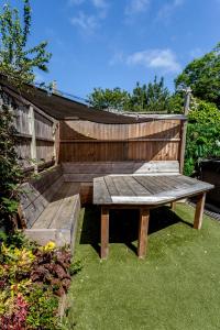 a wooden bench sitting in the grass in a garden at The Old Schoolhouse in Whitstable