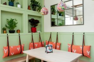 a table with red pillows and plants on a wall at The Old Schoolhouse in Whitstable