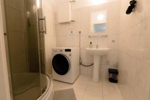 W łazience znajduje się pralka i umywalka. w obiekcie Hidden Peak Guestrooms w Warszawie