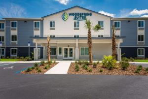 インバネスにあるWoodSpring Suites Invernessの建物の前にヤシの木があるホテル