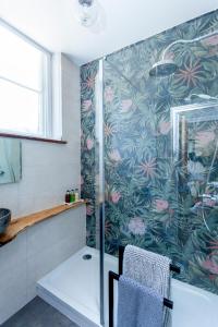 a bathroom with a shower with a glass door at The Old Schoolhouse in Whitstable