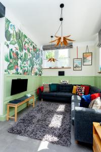 a living room with two couches and a flat screen tv at The Old Schoolhouse in Whitstable