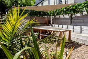 una mesa de picnic de madera en un jardín con plantas en The Old Schoolhouse en Whitstable