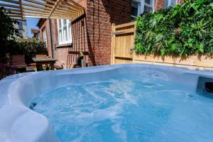 a jacuzzi tub in a yard next to a building at The Old Schoolhouse in Whitstable