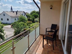 a balcony with a chair and a view of a church at Ferienwohnung Ingeborg 