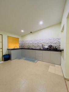a large kitchen with a counter in a room at Sena Yang Indah Homestay in Kangar