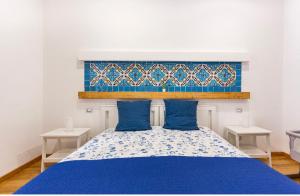 巴勒摩的住宿－Alle Antiche Mura del mercato di Ballarò，卧室配有蓝色和白色的床和两张桌子