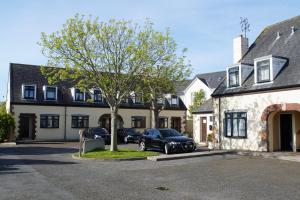 ein Auto, das auf einem Parkplatz vor einem Gebäude geparkt ist in der Unterkunft The Uplands Apartments in Saint Helier Jersey