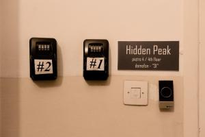 華沙的住宿－Hidden Peak Guestrooms，门上带三个闹钟的墙