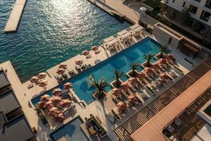 an overhead view of a swimming pool with chairs and umbrellas at Portonovi Resort in Herceg-Novi