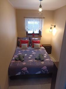 a bedroom with a bed with a purple comforter at Domek na Polance in Istebna