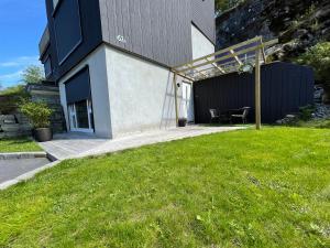 uma casa com um relvado verde em frente em Apartment Lilletveitvegen em Bergen