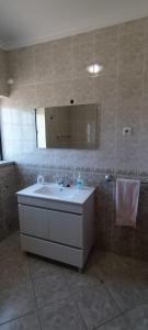 ein Bad mit einem Waschbecken und einem Spiegel in der Unterkunft MaJô Alojamento Local in Tábua