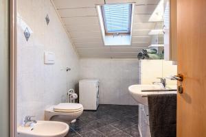 baño con 2 lavabos, aseo y ventana en Weingartnerhof Calendula en San Genesio Atesino