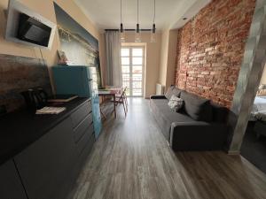 a living room with a couch and a brick wall at Apartamenty Azzurro in Kielce