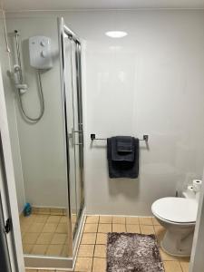 a bathroom with a shower with a toilet and a sink at Bradford Service accommodation in Bradford