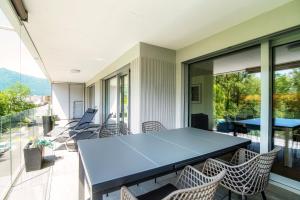 an empty room with a table and chairs on a balcony at Linda Terrace by Quokka 360 - modern one-bedroom flat with sun terrace in Locarno