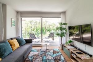 a living room with a couch and a large window at Linda Terrace by Quokka 360 - modern one-bedroom flat with sun terrace in Locarno