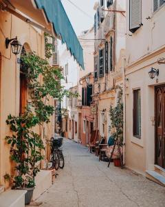 eine Gasse in einer Altstadt mit einem Fahrrad auf der Straße geparkt in der Unterkunft Bruskos luxury in Korfu-Stadt